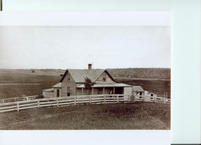 Homestead house with a man standing on the front porch