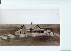 Homestead house with a man standing on the front porch