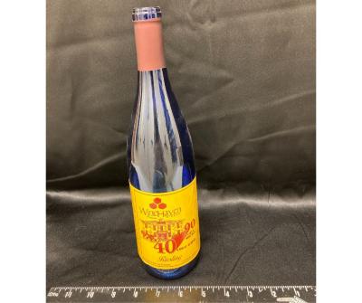 wine bottle with UMM label celebrating the anniversary of 90 years of the West Central School of Agriculture and 40 years of the University of Minnesota Morris, fall 2000. Wine name, Riesling, blue bottle with maroon and gold label.
