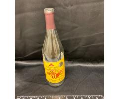 wine bottle with UMM label celebrating the anniversary of 90 years of the West Central School of Agriculture and 40 years of the University of Minnesota Morris, fall 2000. Wine name, Delaware Blush, clear bottle with maroon and gold label.