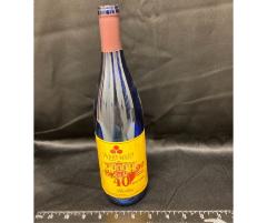 wine bottle with UMM label celebrating the anniversary of 90 years of the West Central School of Agriculture and 40 years of the University of Minnesota Morris, fall 2000. Wine name, Riesling, blue bottle with maroon and gold label.