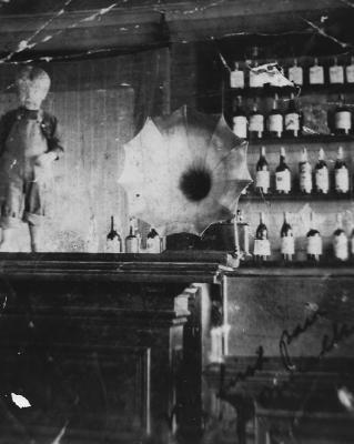 Young Clarence Norby standing on bar in father's saloon in Mallard