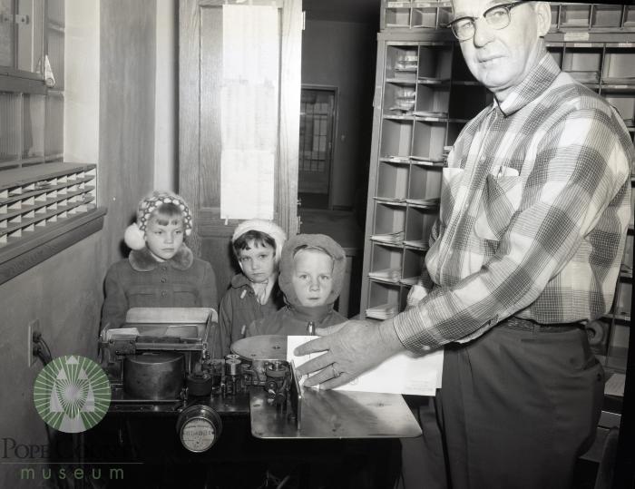 Joel Nelson of the Glenwood, Minnesota post office shows kindergarten students how it is done