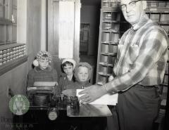 Joel Nelson of the Glenwood, Minnesota post office shows kindergarten students how it is done