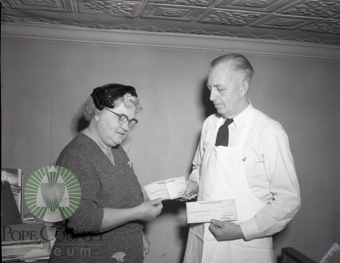 Harry Anderson, Mrs. Ray Overmire admire Quaker Oats Checks. Glenwood, Minnesota