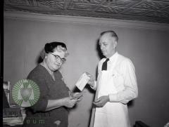 Harry Anderson, Mrs. Ray Overmire admire Quaker Oats Checks. Glenwood, Minnesota