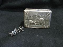 10 jacks and an old chain in a metal box with a horse drawn carriage on the lid