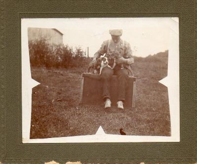 Black and white photograph of Dean Mastenbrook with puppies in his lap
