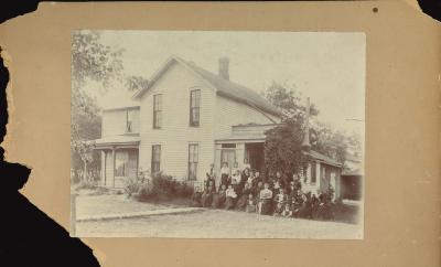 Photo of a house with a large group of people on the lawn