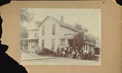 Photo of a house with a large group of people on the lawn