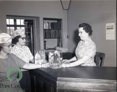 Carol Dokken and Donna Hagen giving Books to Kathryn Nelson