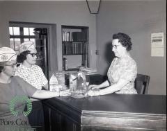 Carol Dokken and Donna Hagen giving Books to Kathryn Nelson
