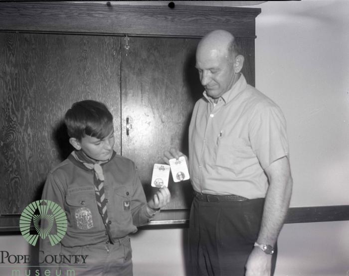 Unidentified Man and Boy from troop 423 holding two badges.
