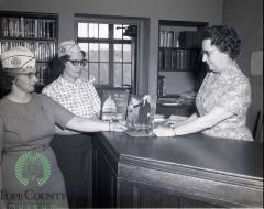 Kathryn Nelson the Central school librarian Receiving books From Minnewaska VFW Auxiliary members Carol Dokken and Donna Hagen