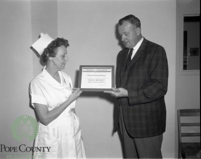 William MacGregor presenting Dina Bremness Medicare Plaque
