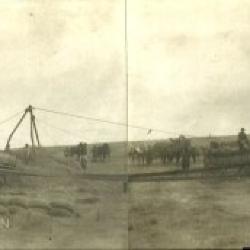 Panoramic photo of a thrashing machine and crew in the field