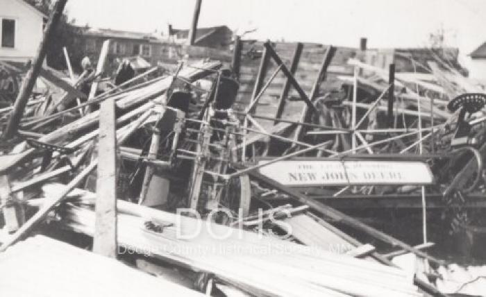 Black and white photograph of implement building damaged