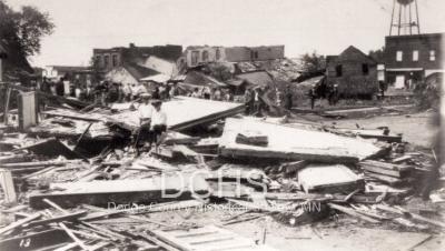 Black and white photograph of several heavily damaged buildings in Hayfield