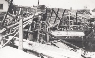 Black and white photograph of implement building damaged