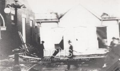 Photograph of building in middle of street from tornado
