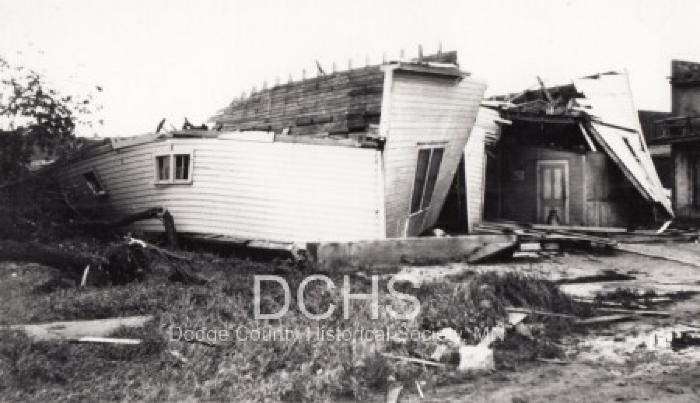 Black and white photograph of several buildings damaged by tornado