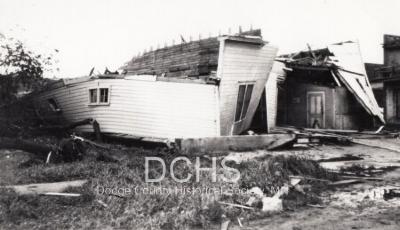 Black and white photograph of several buildings damaged by tornado