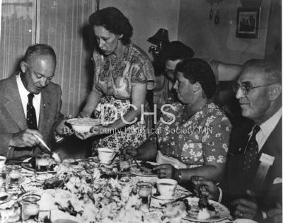 Black and white photograph of Eisenhower eating at meal at the Snow house