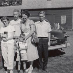 Black and white snapshot of a family in a farm yard